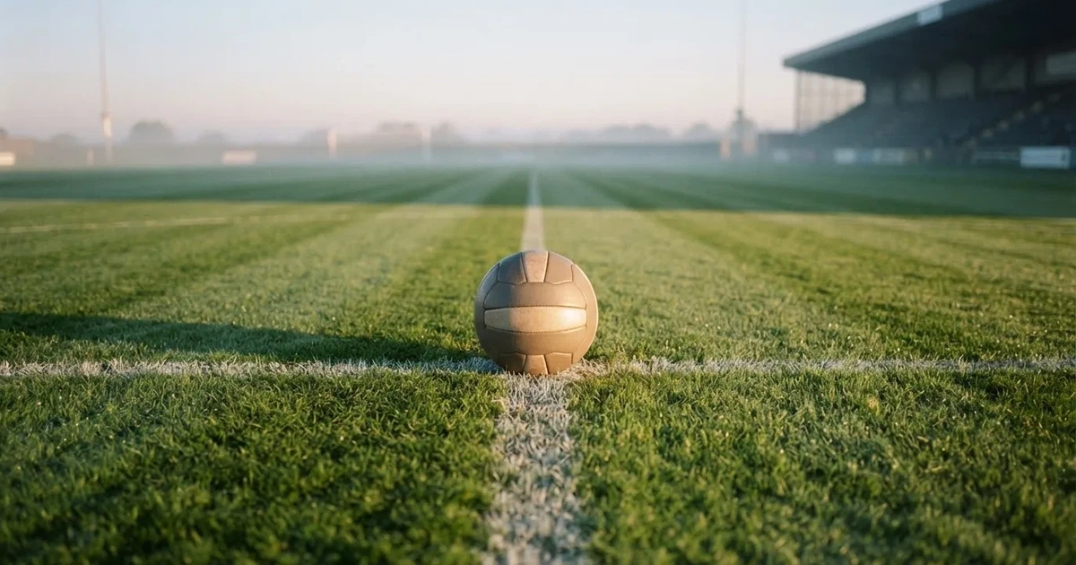 Un balón en el punto central de un campo de césped a la luz de la mañana